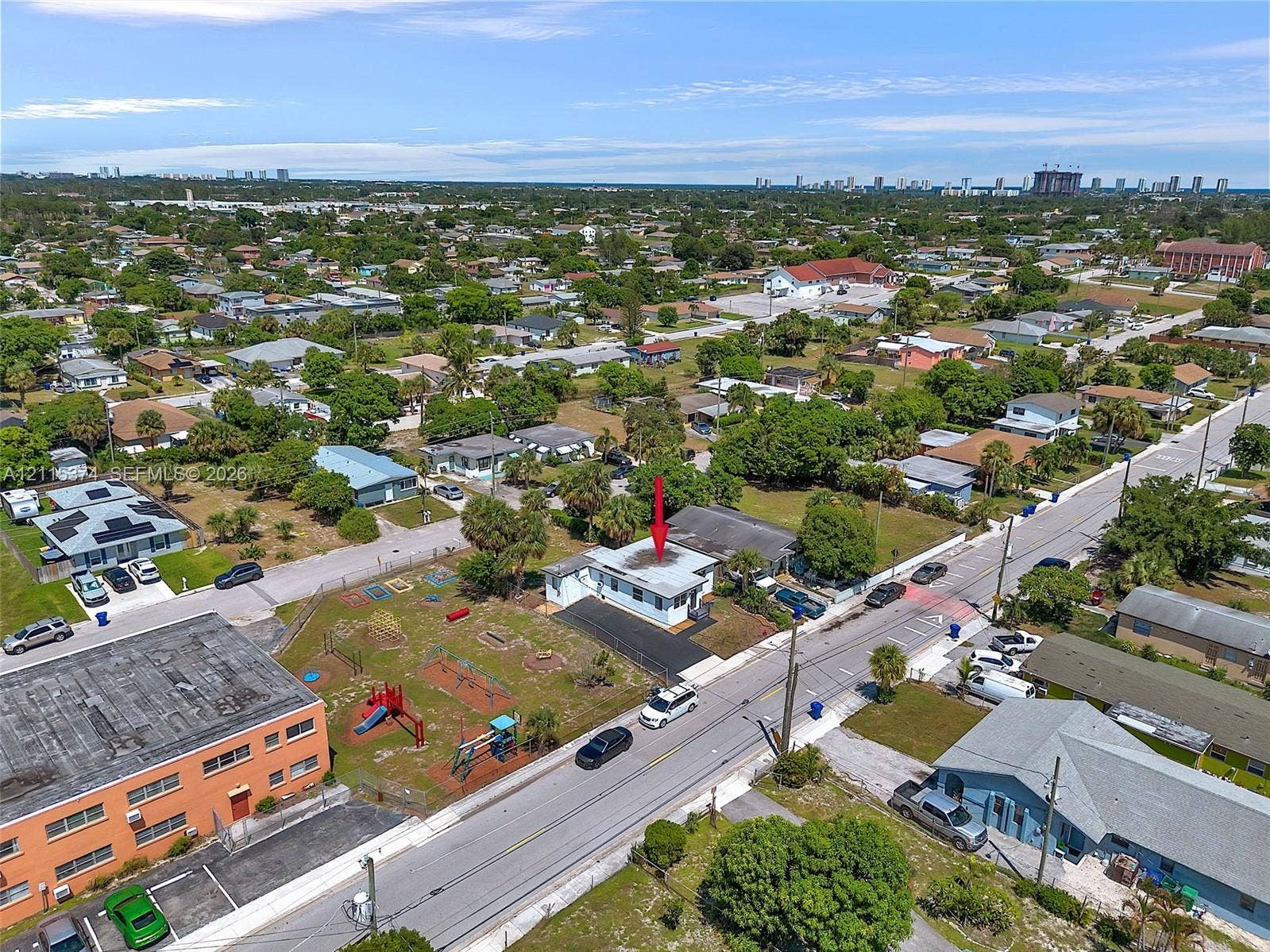 Aerial perspective featuring a detached residential structure, asphalt driveway, and mature landscaping