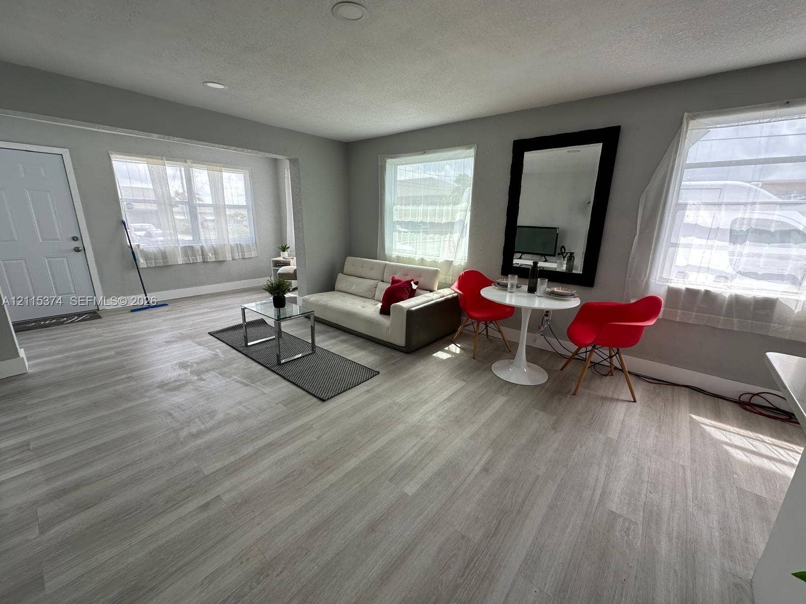 Living area featuring wood-finish flooring, recessed lighting, and multiple windows with natural light