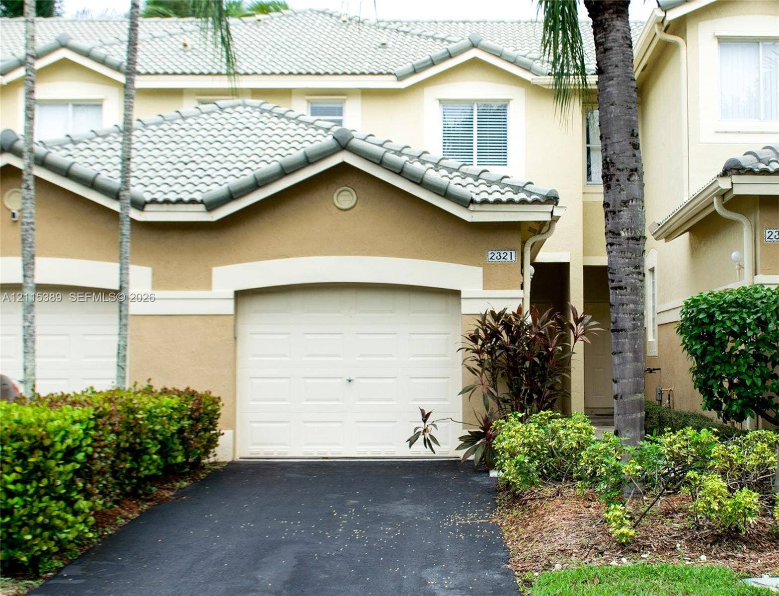 2321 Cordoba Bend, Weston, FL 33327 Exterior featuring a dual-pitch tile roof, arched garage entrance, and multi-pane windows