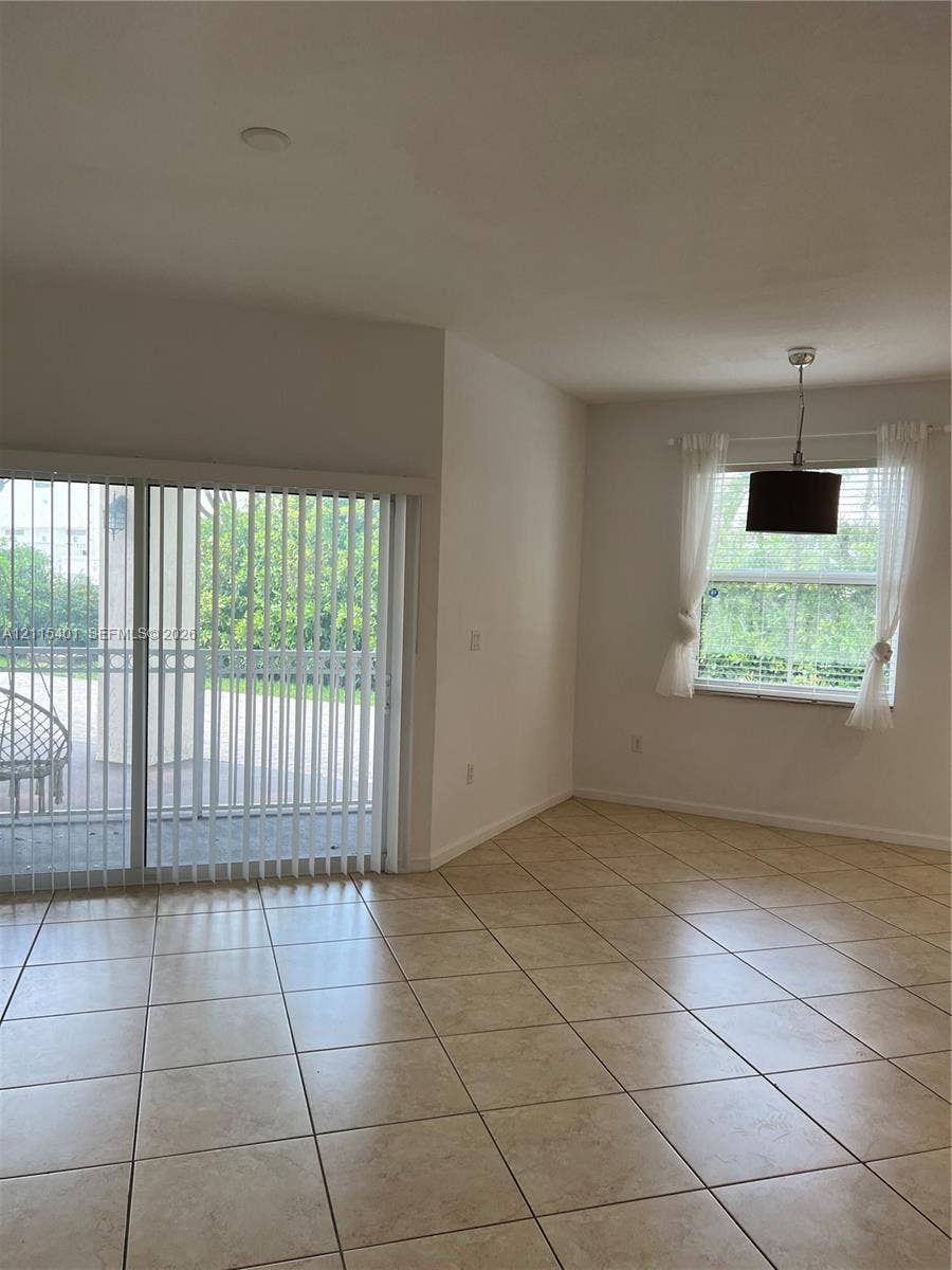 11503 NW 89th Street, #104, Doral, Doral, FL 33178 Neutral ceramic tile flooring, large sliding glass door, and overhead pendant lighting fixture