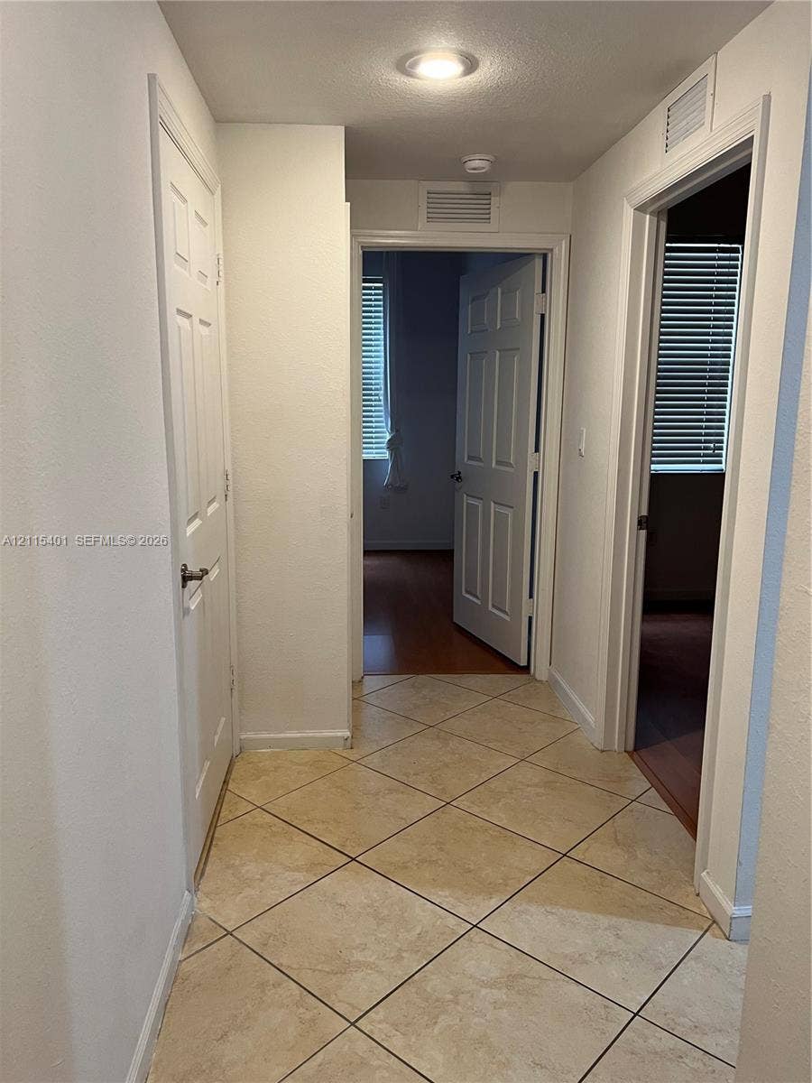 11503 NW 89th Street, #104, Doral, Doral, FL 33178 Neutral-toned tile flooring set in a diagonal pattern, complemented by six-panel interior doors and recessed lighting