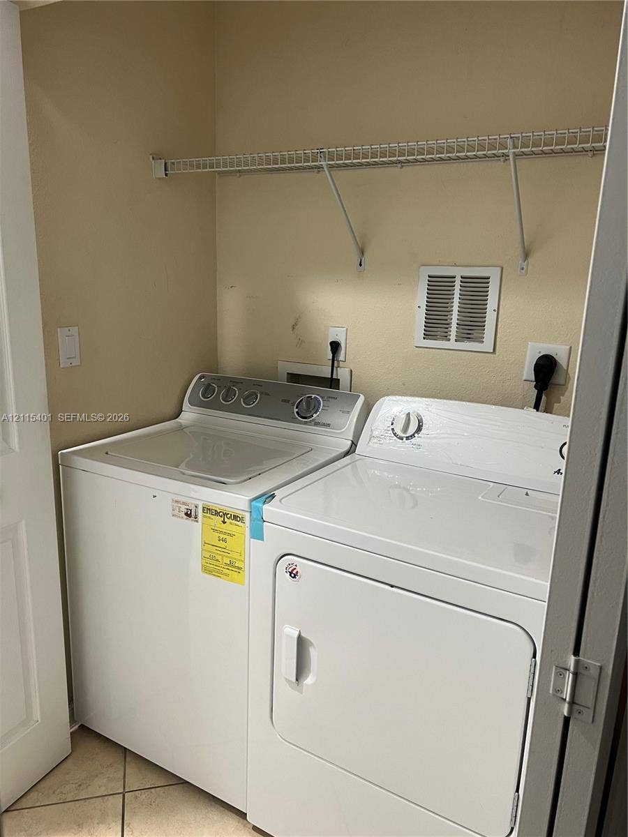 11503 NW 89th Street, #104, Doral, Doral, FL 33178 Dedicated laundry area featuring tile flooring and an integrated wire shelving unit