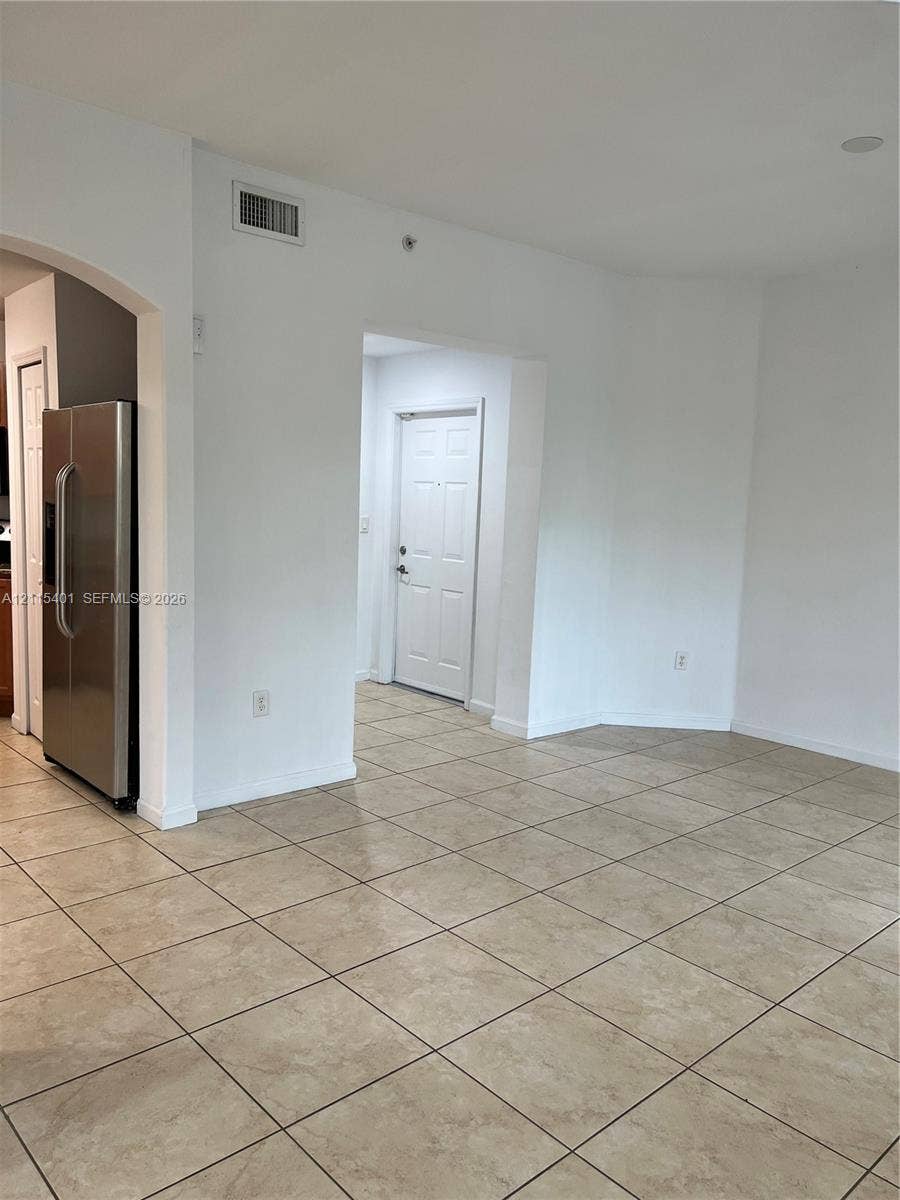 11503 NW 89th Street, #104, Doral, Doral, FL 33178 Neutral-toned tile flooring, arched entryways, and a stainless steel refrigerator