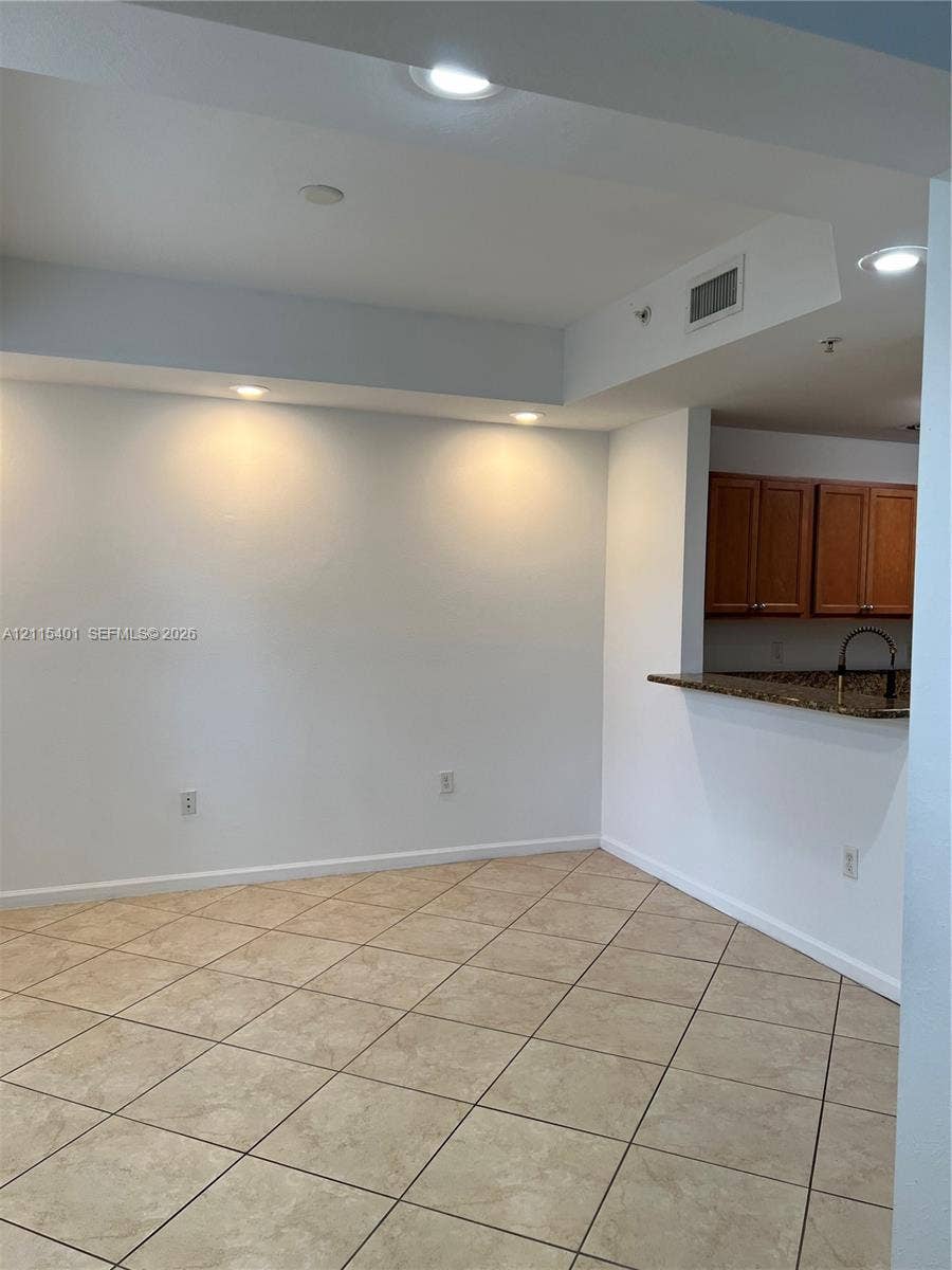 11503 NW 89th Street, #104, Doral, Doral, FL 33178 Tile flooring, recessed lighting, and a kitchen pass-through counter featuring stone-surface countertops and wood-finish cabinetry
