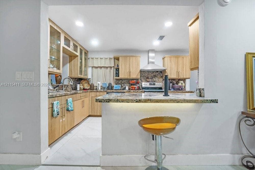 20302 NW 39th Court, Miami Gardens, FL 33055 Kitchen featuring light-finish cabinetry, stone-style countertops, stainless steel vent hood, recessed lighting, and tile flooring