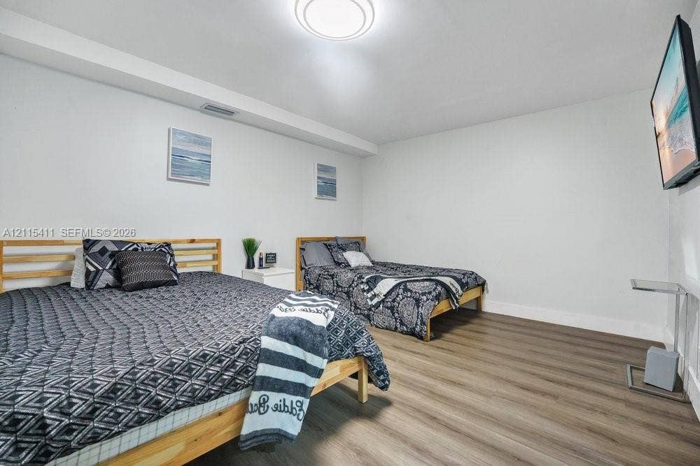 20302 NW 39th Court, Miami Gardens, FL 33055 Spacious room featuring wood-finish flooring and a flush-mount ceiling light fixture