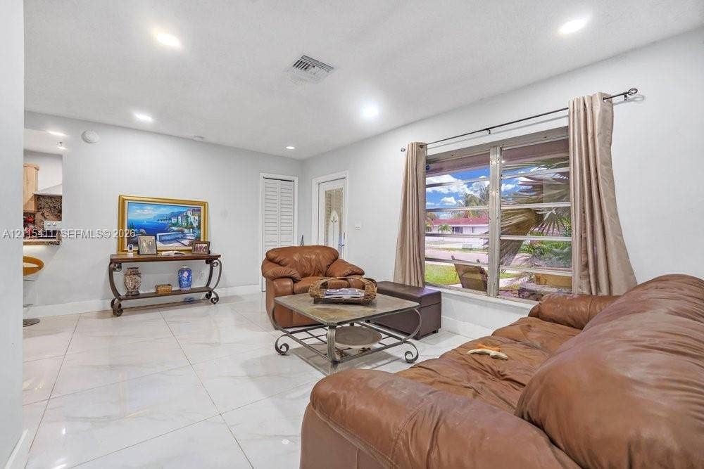 20302 NW 39th Court, Miami Gardens, FL 33055 Polished tile flooring, recessed ceiling lighting, and large window with multi-pane glass