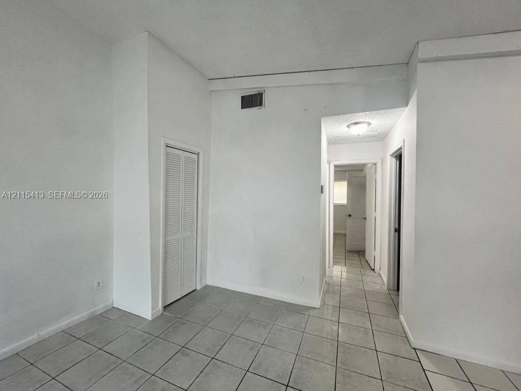 3001 NW 4th Terrace, #173, Pompano Beach, Pompano Beach, FL 33064 Neutral-toned ceramic tile flooring, high ceilings with exposed structural beam, and built-in louvered closet doors