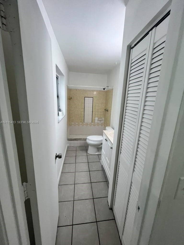3001 NW 4th Terrace, #173, Pompano Beach, Pompano Beach, FL 33064 Bathroom featuring a tiled shower enclosure, white vanity cabinet, ceramic tile flooring, and a louvered closet door
