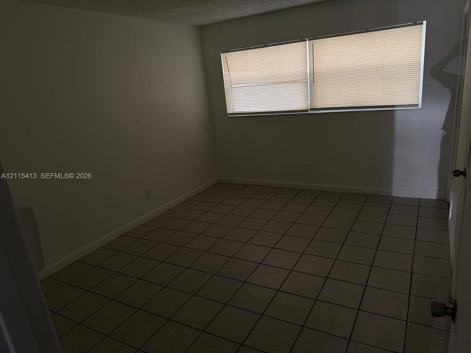 3001 NW 4th Terrace, #173, Pompano Beach, Pompano Beach, FL 33064 Interior space featuring neutral-toned tile flooring, light-colored walls, and large horizontal windows equipped with integrated blinds