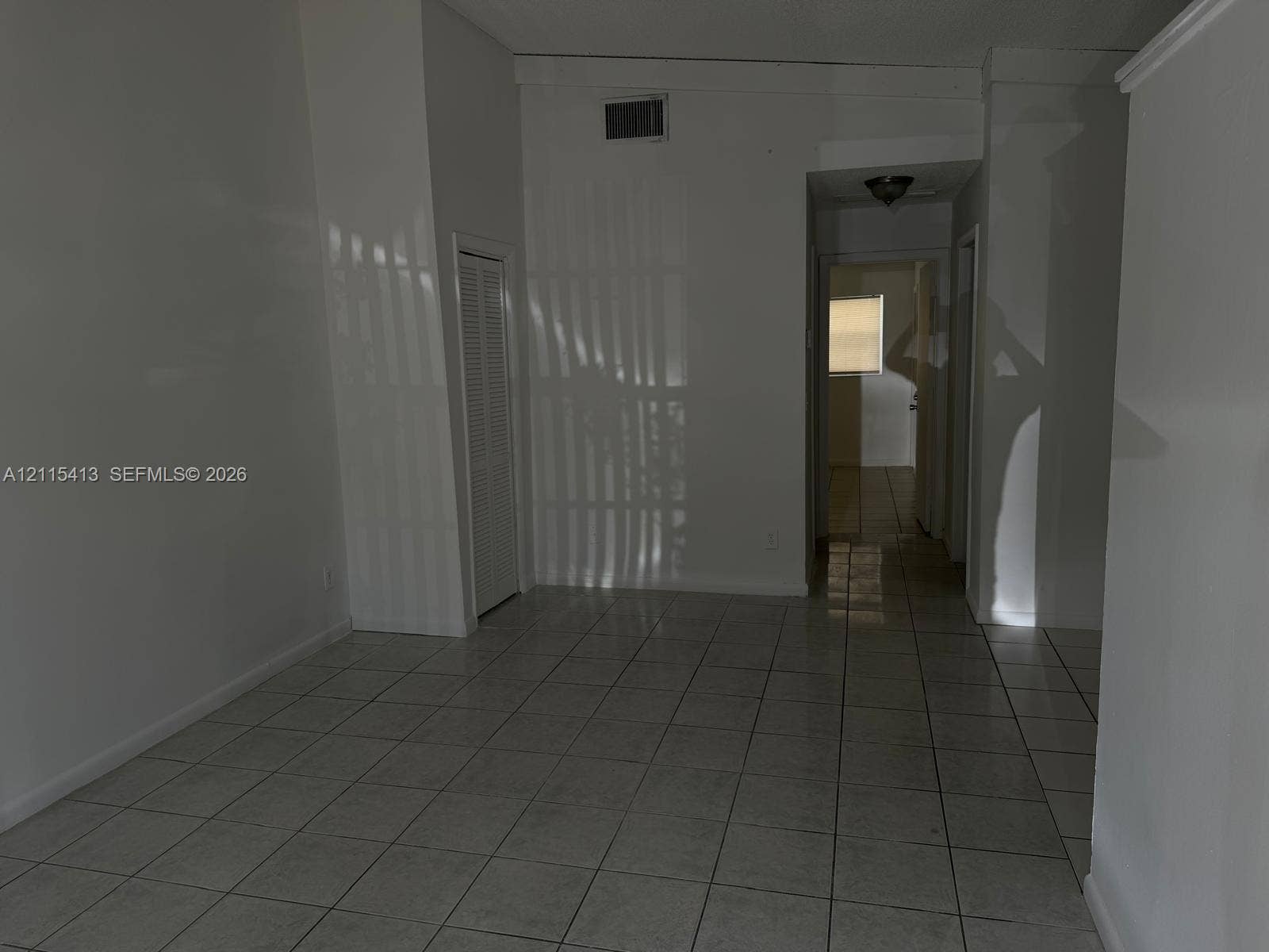 3001 NW 4th Terrace, #173, Pompano Beach, Pompano Beach, FL 33064 Interior space featuring white walls, ceramic tile flooring, a louvered closet door, and a flush-mount ceiling light fixture