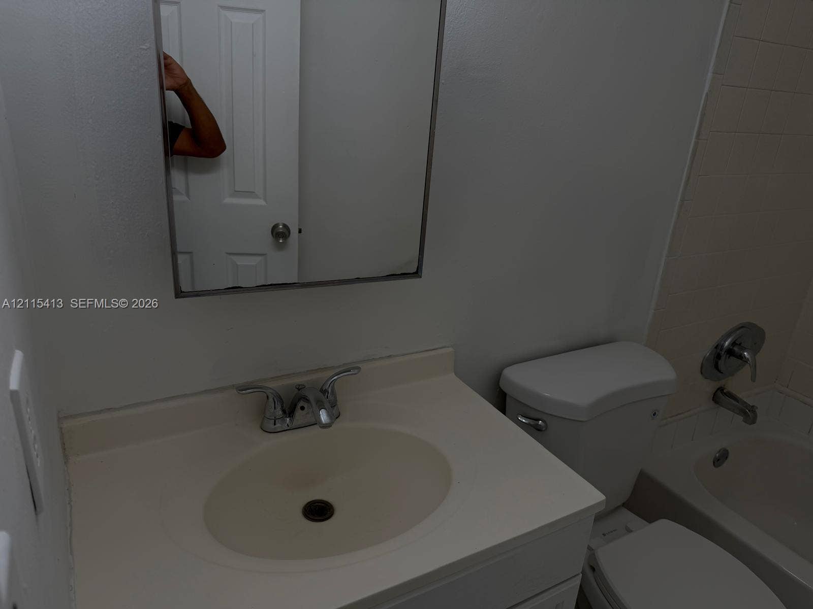 3001 NW 4th Terrace, #173, Pompano Beach, Pompano Beach, FL 33064 Bathroom vanity featuring an integrated oval sink basin, chrome-finish dual-handle faucet, frameless wall-mounted mirror, and combination shower and tub enclosure with chrome fixtures
