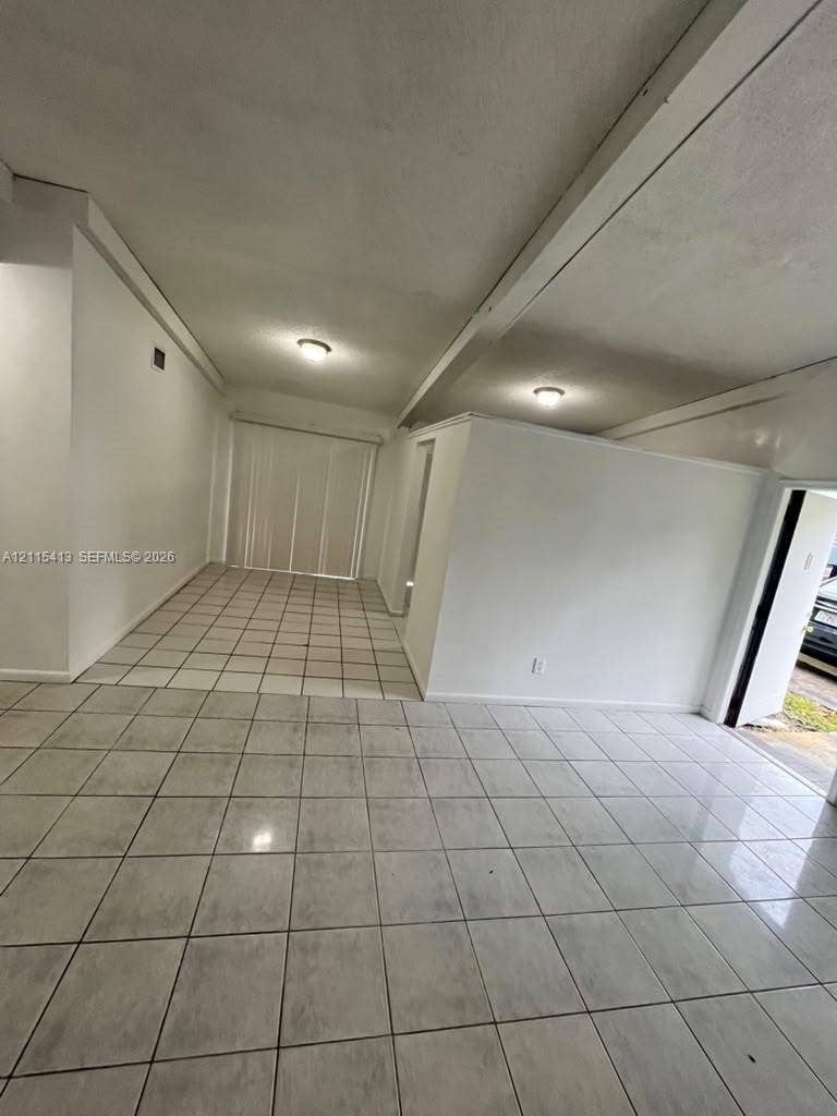 3001 NW 4th Terrace, #173, Pompano Beach, Pompano Beach, FL 33064 Interior space featuring ceramic tile flooring, neutral wall finishes, exposed structural beams, flush-mount lighting, and vertical blinds