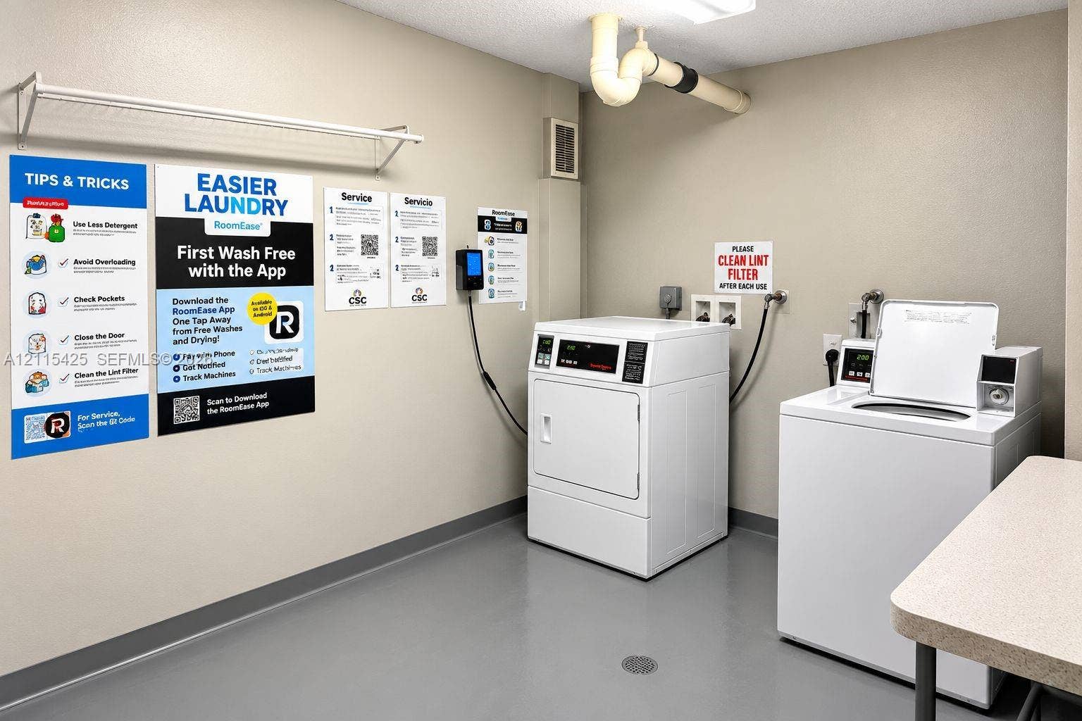 550 Bayshore Drive, #404, Fort Lauderdale, FL 33304 Laundry area featuring industrial-grade washers and dryers, a metal wall-mounted drying rack, and durable flooring