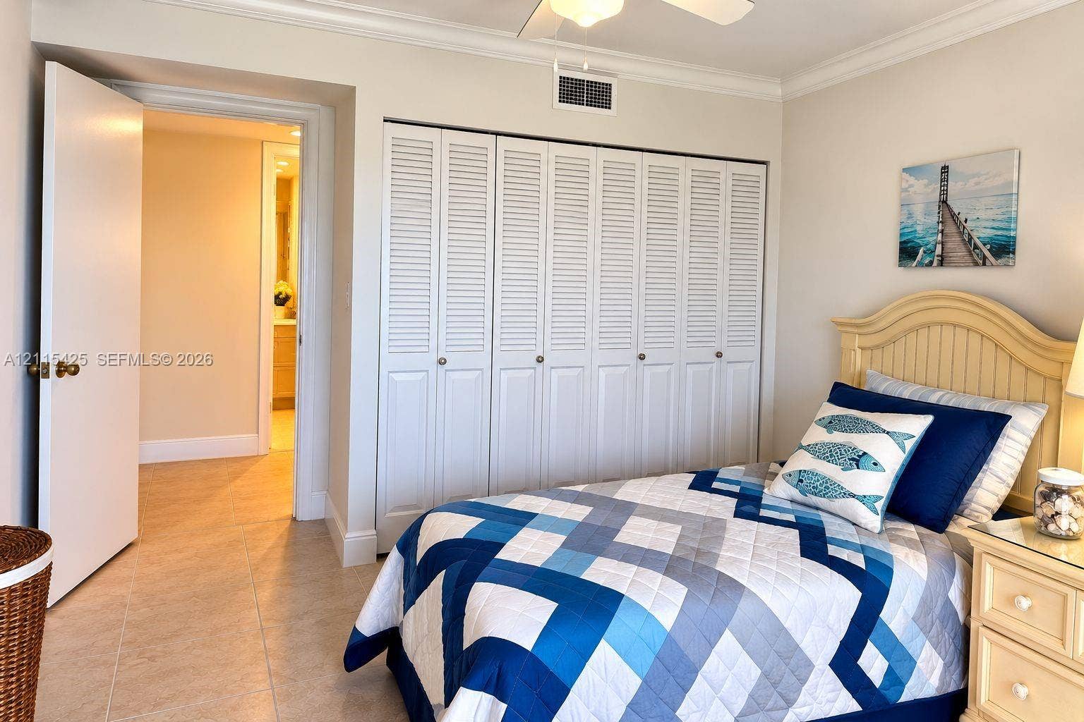 550 Bayshore Drive, #404, Fort Lauderdale, FL 33304 Neutral-tone room featuring tile flooring, crown molding, a ceiling fan, and floor-to-ceiling bi-fold closet doors