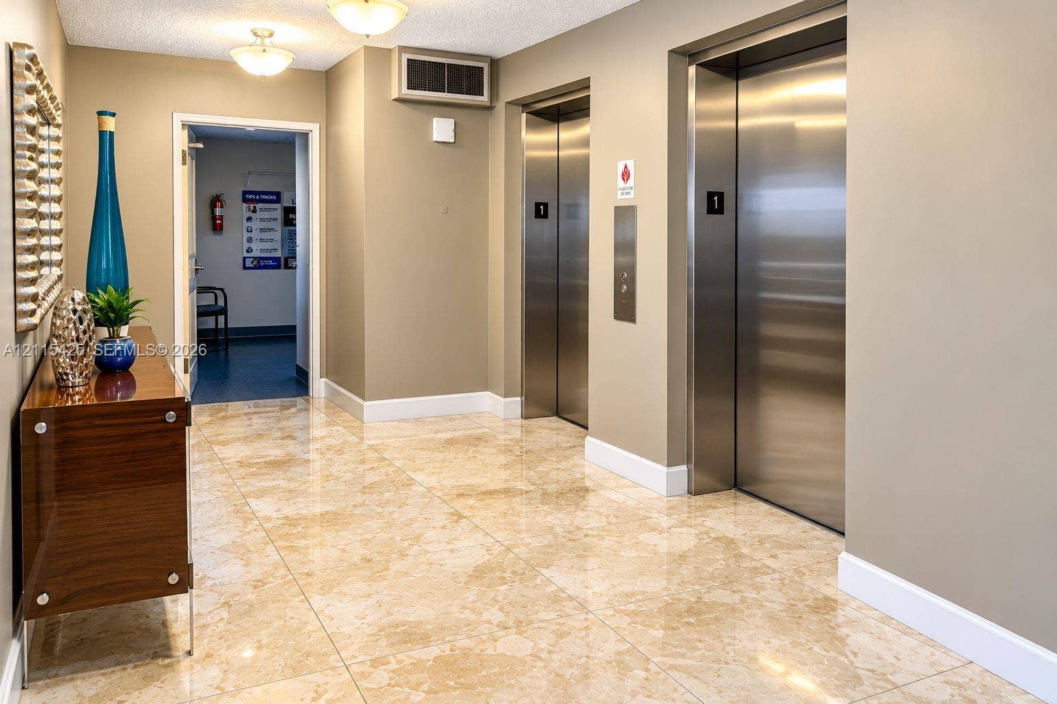 550 Bayshore Drive, #404, Fort Lauderdale, FL 33304 Common area lobby featuring polished stone flooring, dual stainless steel elevators, and recessed overhead lighting