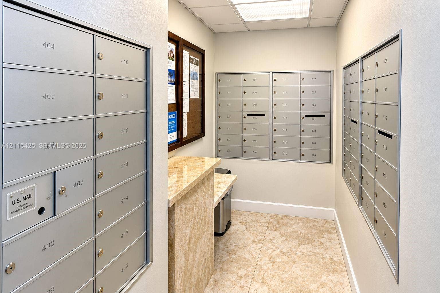 550 Bayshore Drive, #404, Fort Lauderdale, FL 33304 Dedicated mailroom featuring recessed metallic mailboxes, stone-surfaced counter, and stone-tile flooring