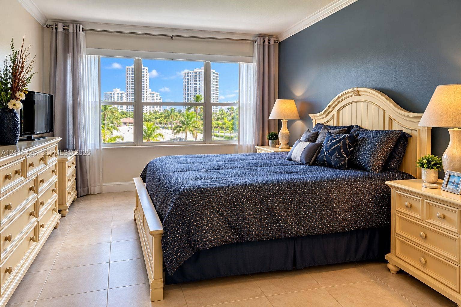 550 Bayshore Drive, #404, Fort Lauderdale, FL 33304 Bedroom featuring large multi-pane windows, crown molding, neutral tile flooring, and an accent wall