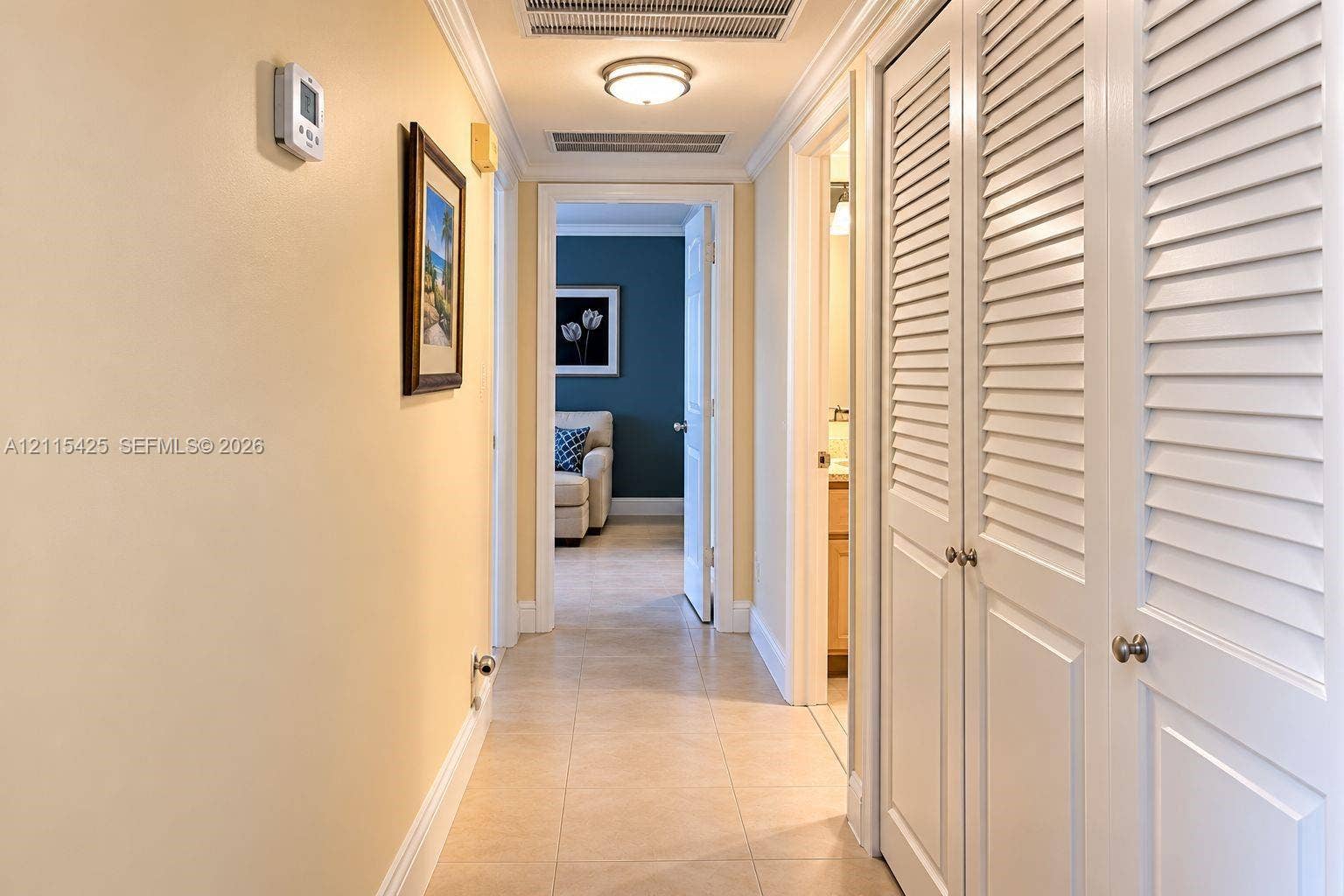 550 Bayshore Drive, #404, Fort Lauderdale, FL 33304 Hallway featuring large-format tile flooring, crown molding, and white louvered-style closet doors