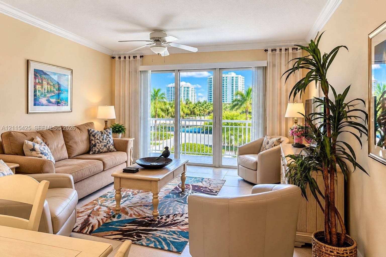 550 Bayshore Drive, #404, Fort Lauderdale, FL 33304 Living area featuring tile flooring, crown molding, a ceiling fan, and floor-to-ceiling sliding glass doors opening to a private balcony