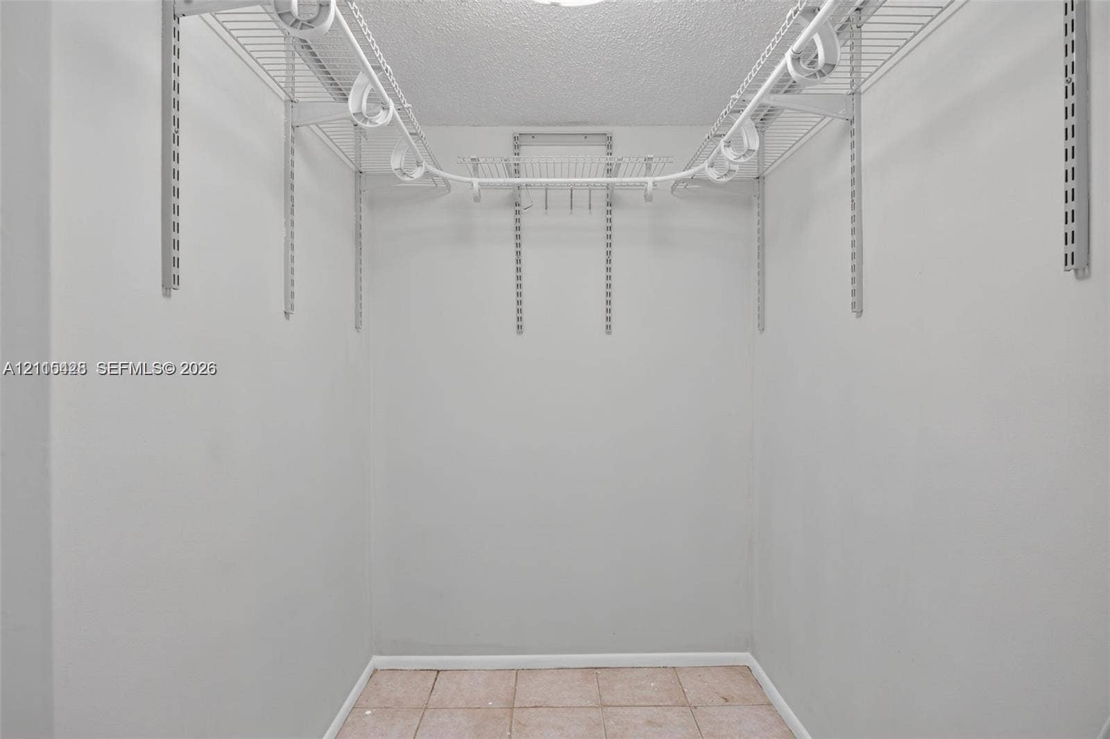 503 Gardens Drive, #201, Pompano Beach, Pompano Beach, FL 33069 Storage space featuring adjustable wall-mounted metal shelving, white support tracks, and tile flooring