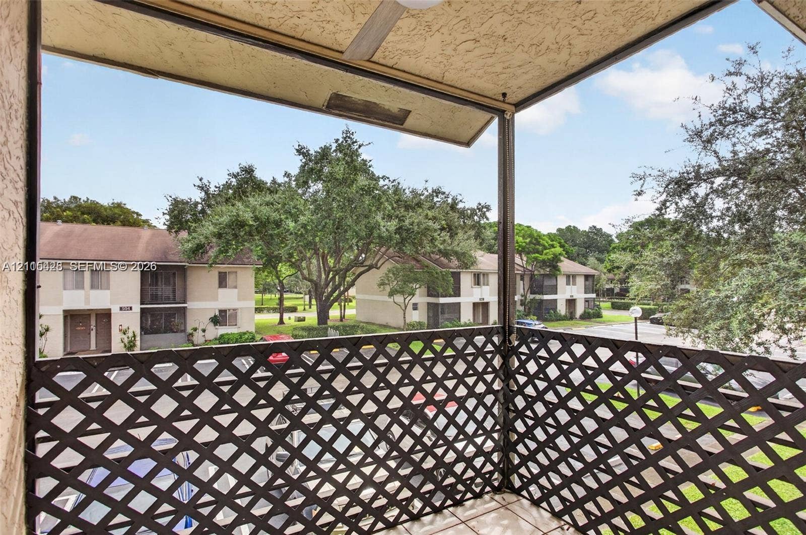 503 Gardens Drive, #201, Pompano Beach, Pompano Beach, FL 33069 Covered balcony featuring a diamond-patterned lattice railing and a mounted ceiling fan