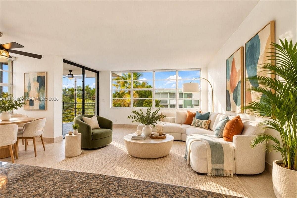 Open-concept interior featuring large-format tile flooring, oversized multi-pane windows, and a sliding glass door