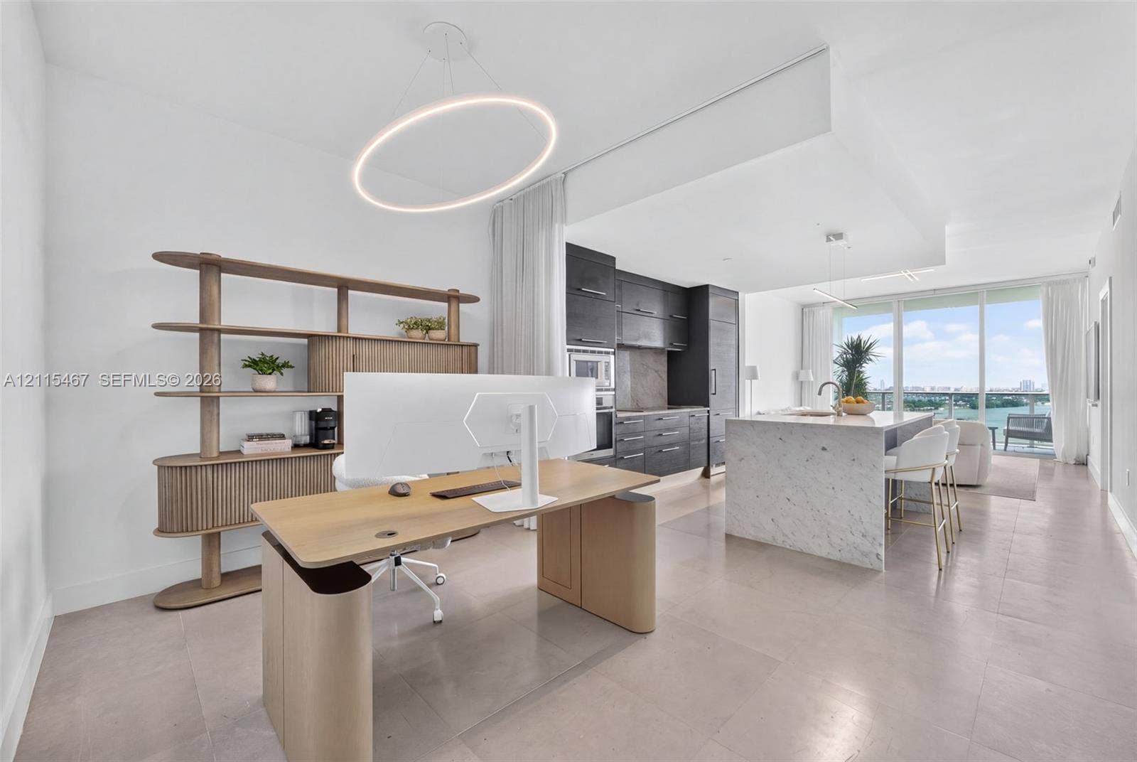 900 Biscayne Boulevard, #2104, Miami, FL 33132 Kitchen featuring dark cabinetry, stone-clad island with waterfall edge, integrated appliances, and large-format tile flooring, accented by a circular LED light fixture