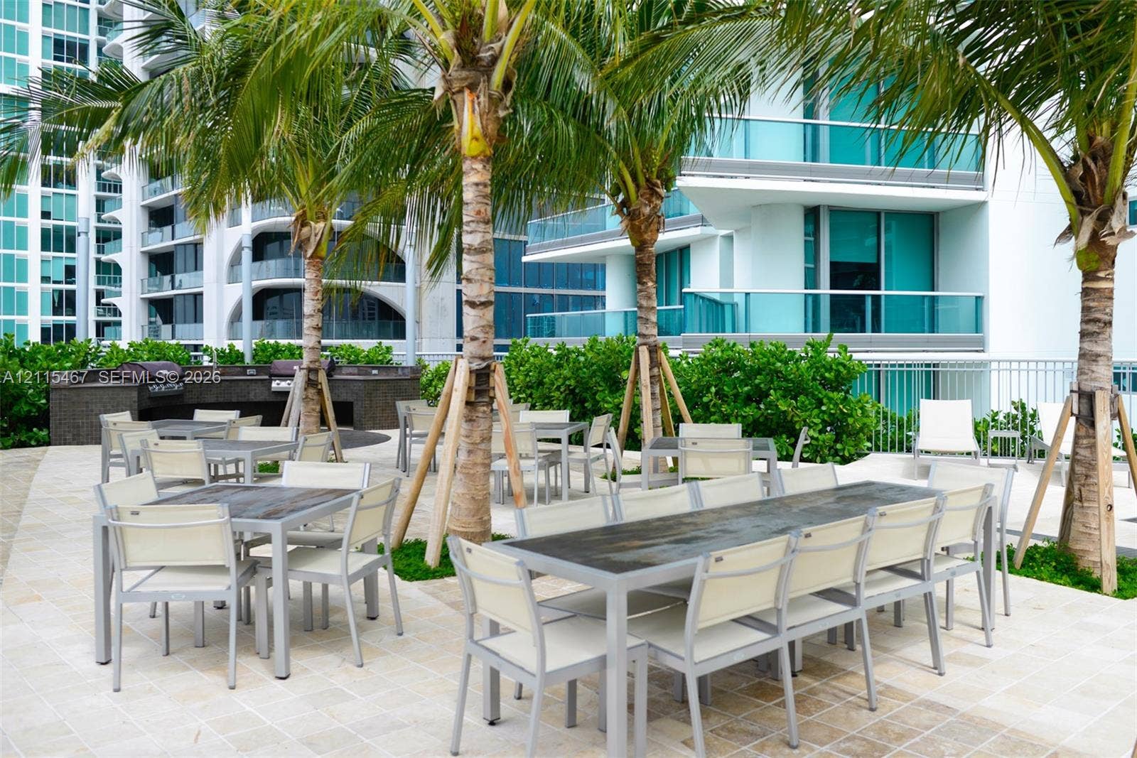 900 Biscayne Boulevard, #2104, Miami, FL 33132 Outdoor terrace featuring stone tile flooring, built-in stone-finish kitchen station, metal railings, and integrated landscaping