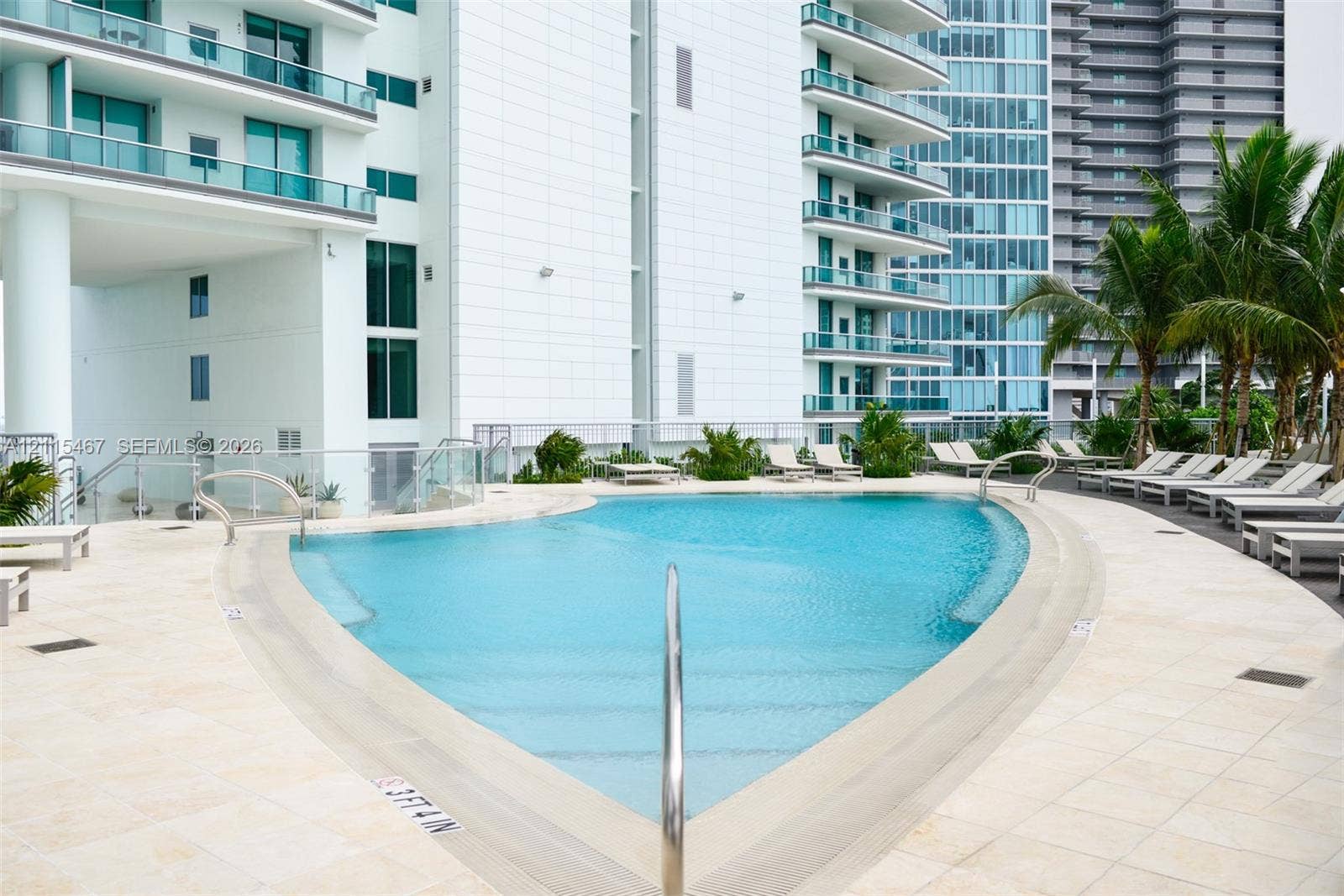900 Biscayne Boulevard, #2104, Miami, FL 33132 Curved swimming pool featuring stone-tile decking, integrated entry steps, and polished metal handrails