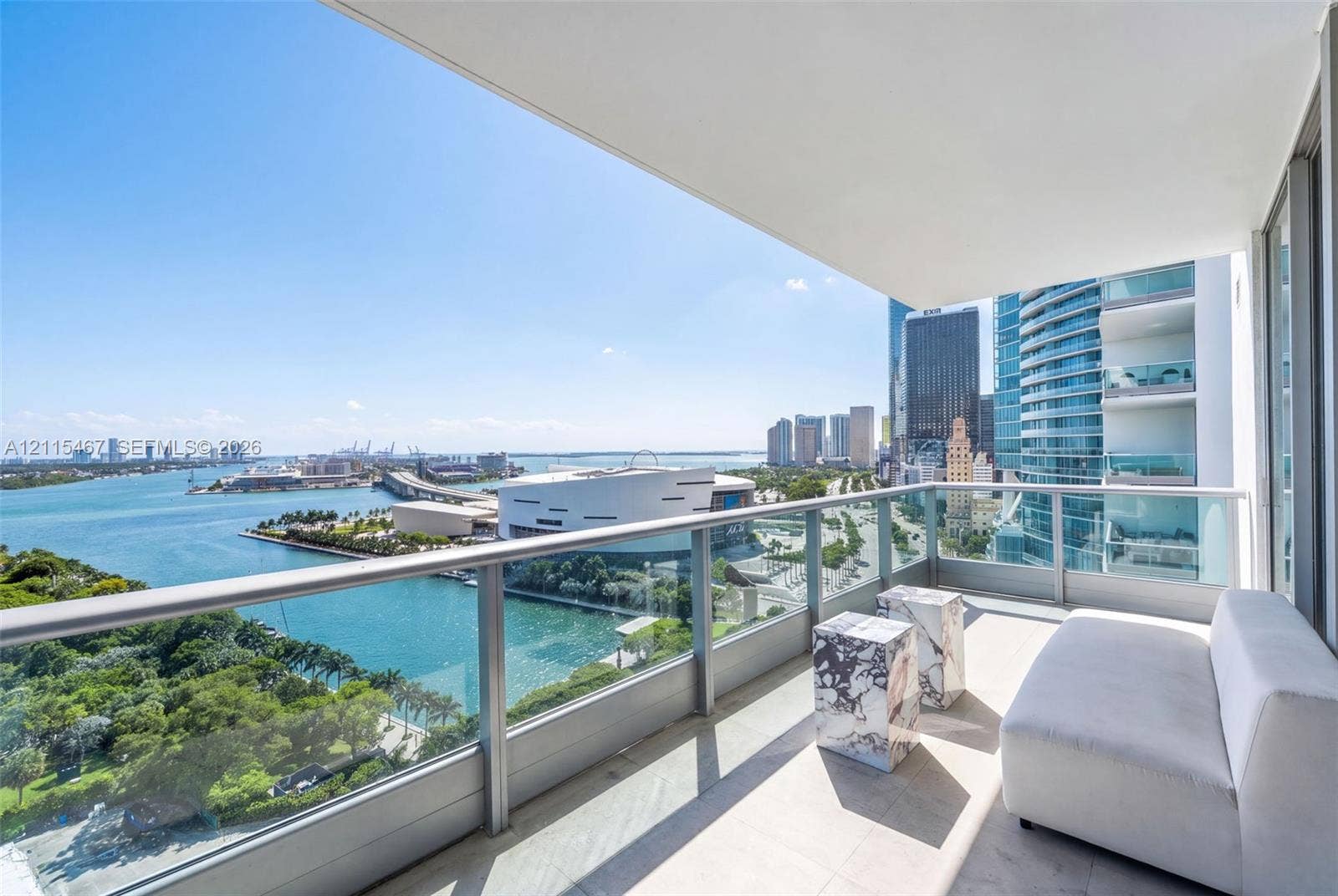 900 Biscayne Boulevard, #2104, Miami, FL 33132 Covered balcony with a glass and metal railing, concrete flooring, and water and urban skyline backdrop
