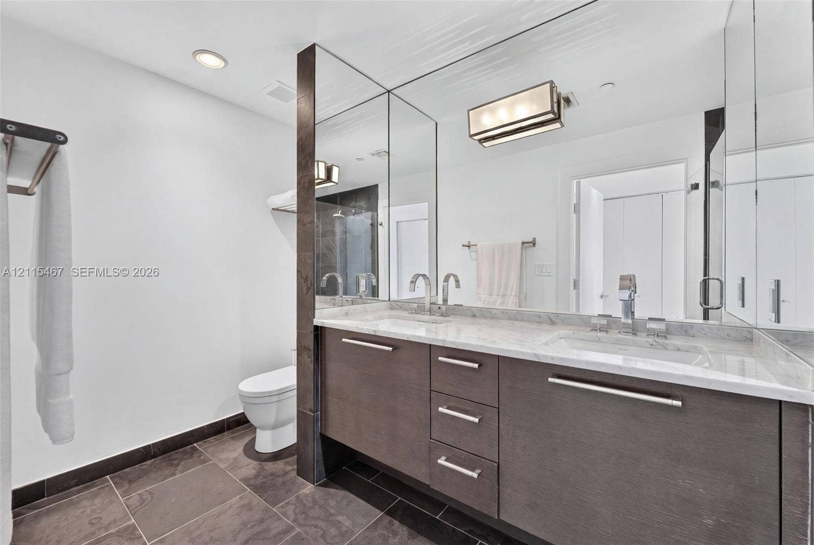 900 Biscayne Boulevard, #2104, Miami, FL 33132 Dual-sink vanity with stone countertop, dark wood-finish cabinetry, full-height wall mirror, and large-format floor tile