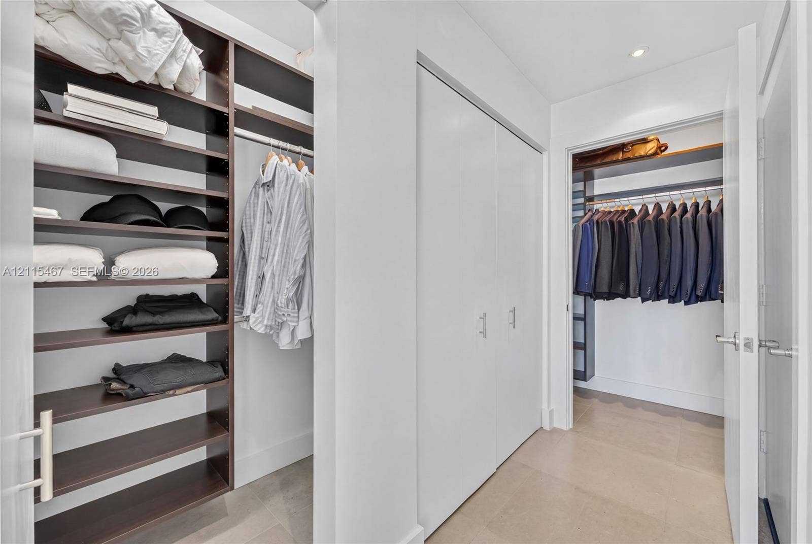 900 Biscayne Boulevard, #2104, Miami, FL 33132 Custom closet organization system featuring dark wood-finish open shelving, built-in hanging rods, and white double-door cabinetry with metallic hardware
