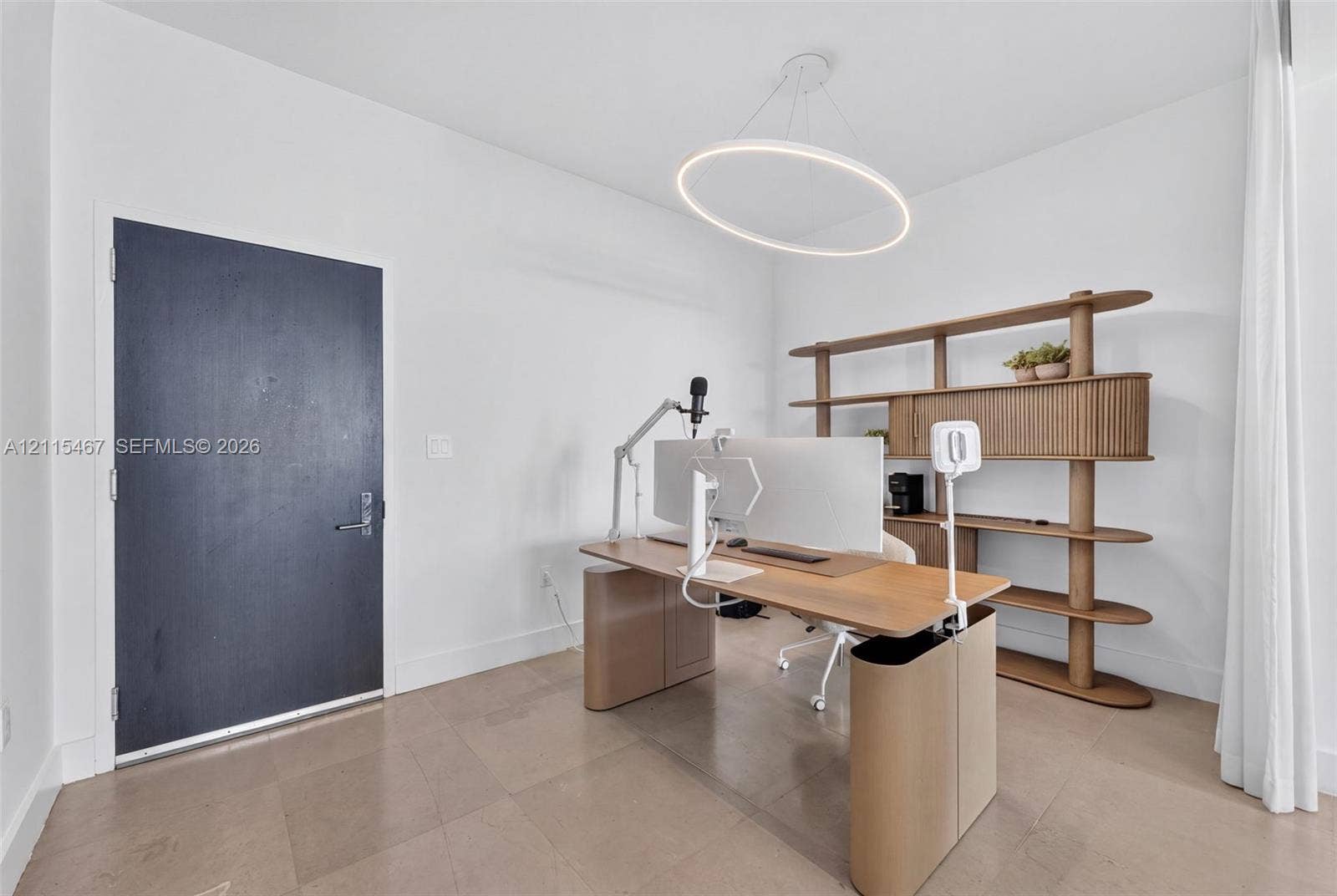 900 Biscayne Boulevard, #2104, Miami, FL 33132 Minimalist room featuring large-format tile flooring, a modern circular LED pendant light, and a solid dark-finish entry door