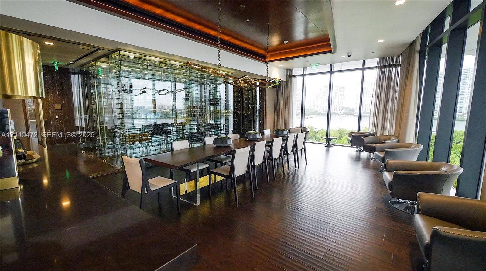 Floor-to-ceiling glass wall, temperature-controlled glass wine display, dark wood-finish flooring, coffered ceiling with recessed lighting, and sculptural pendant fixture