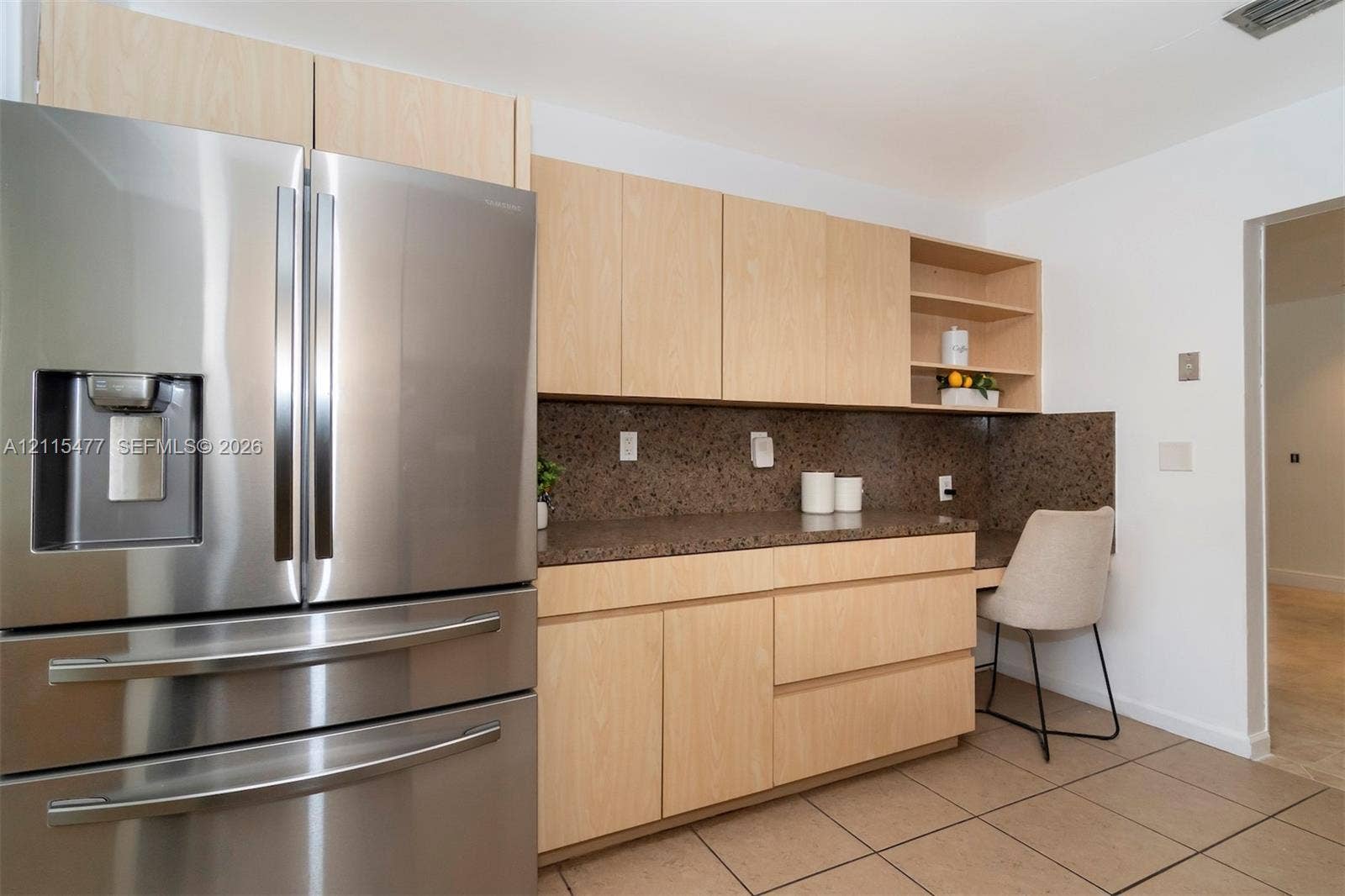 2510 NE 208th Terrace, Miami, FL 33180 Kitchen area featuring light wood-finish cabinetry, a stainless steel refrigerator, stone-finish countertops, tile flooring, and integrated open shelving