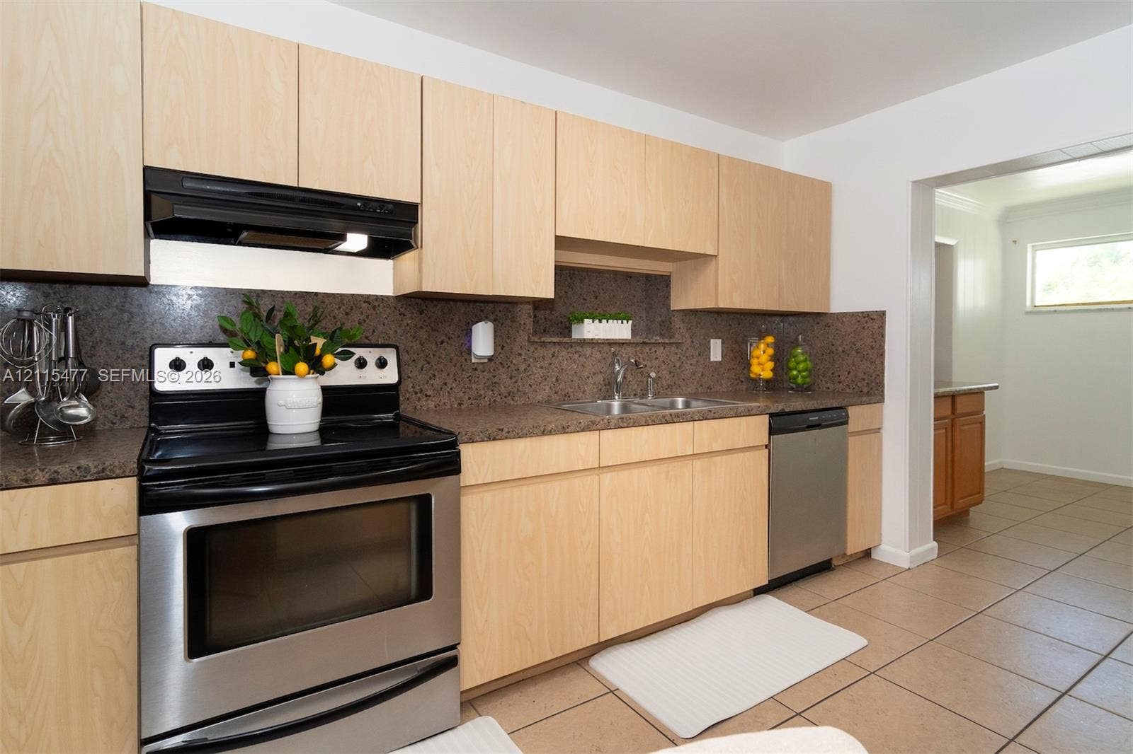 2510 NE 208th Terrace, Miami, FL 33180 Kitchen featuring flat-panel wood cabinetry, speckled stone-finish countertops, stainless steel range with overhead hood, stainless steel dishwasher, and ceramic tile flooring