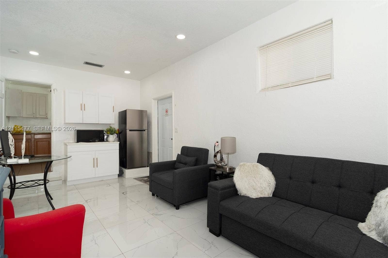 2510 NE 208th Terrace, Miami, FL 33180 Open living space featuring light-colored tile flooring, recessed lighting, white cabinetry, and a horizontal window
