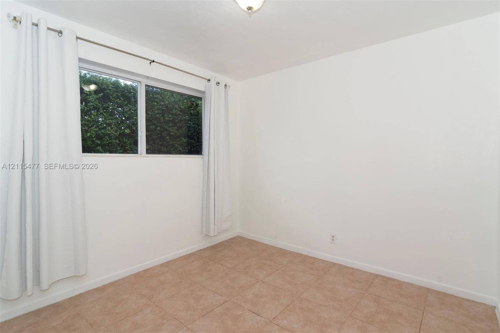 2510 NE 208th Terrace, Miami, FL 33180 Neutral-toned ceramic tile flooring, clean white wall finishes, and a single-pane horizontal sliding window