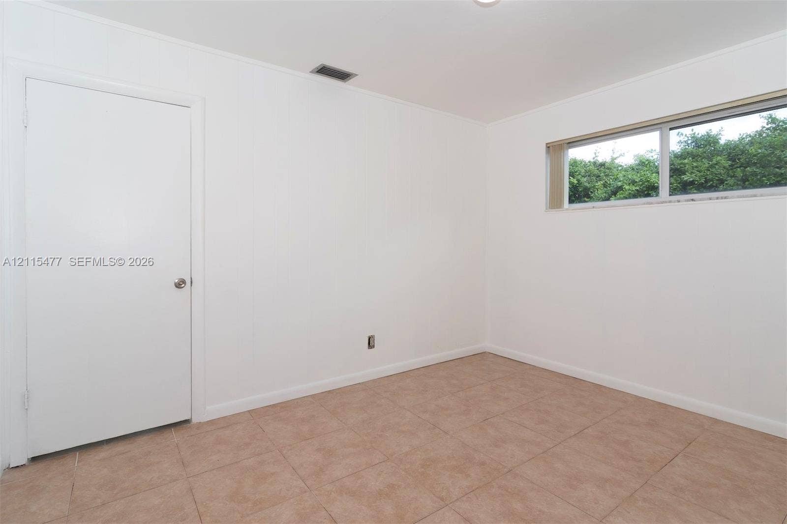 2510 NE 208th Terrace, Miami, FL 33180 Interior room featuring neutral wall finishes, tile flooring, and a single-pane sliding window