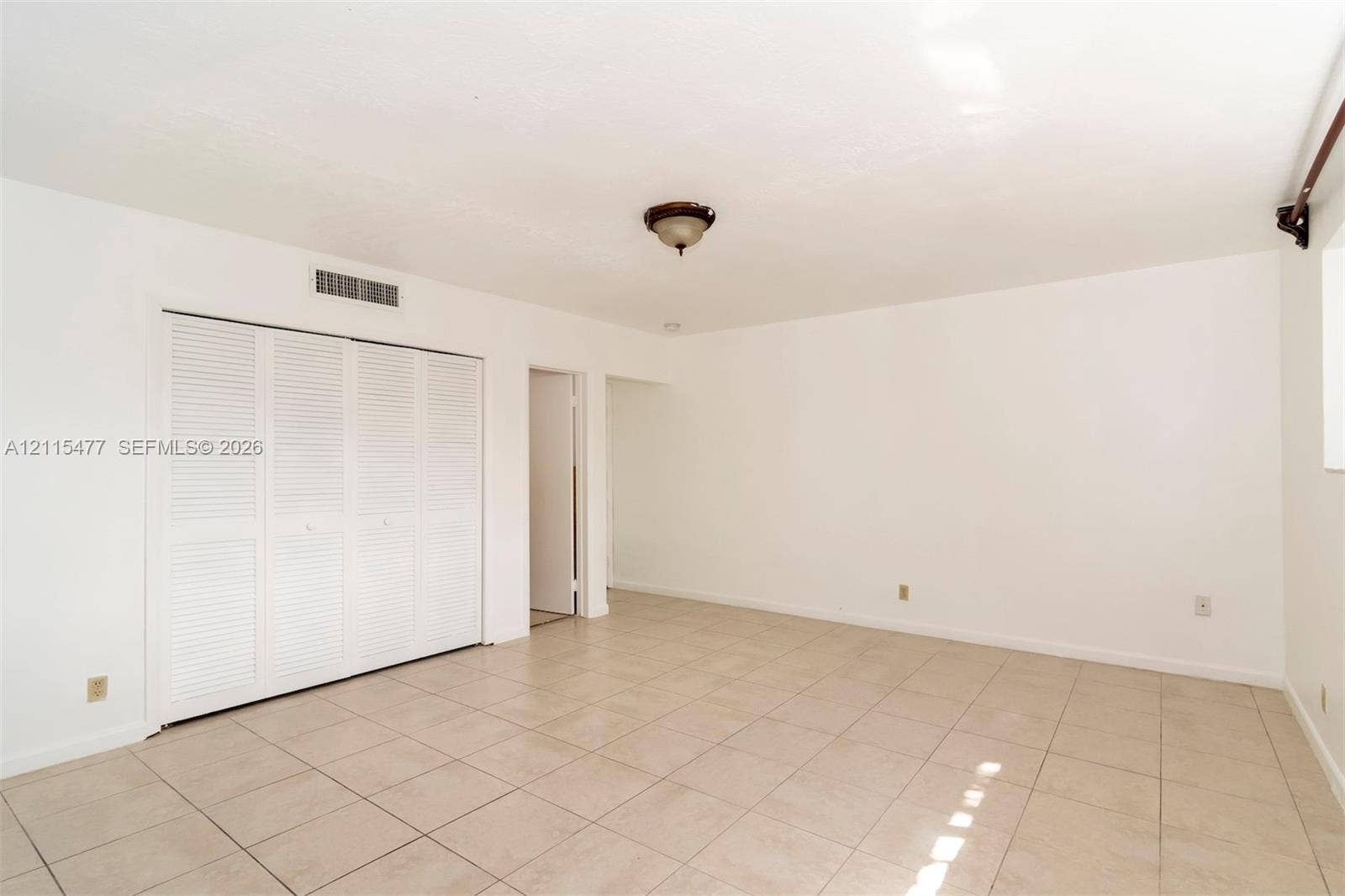 2510 NE 208th Terrace, Miami, FL 33180 Neutral-toned ceramic tile flooring, ceiling-mounted light fixture, and closet with white louvered bifold doors