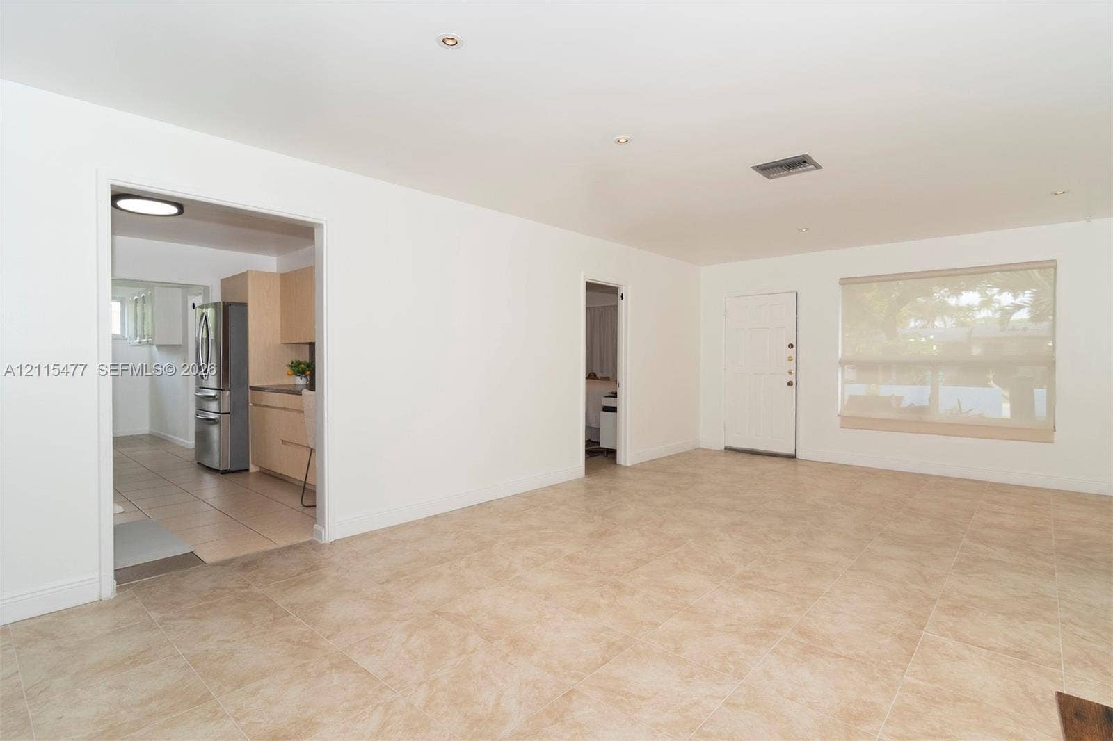 2510 NE 208th Terrace, Miami, FL 33180 Neutral-toned tile flooring, recessed ceiling lighting, and large window with integrated shade