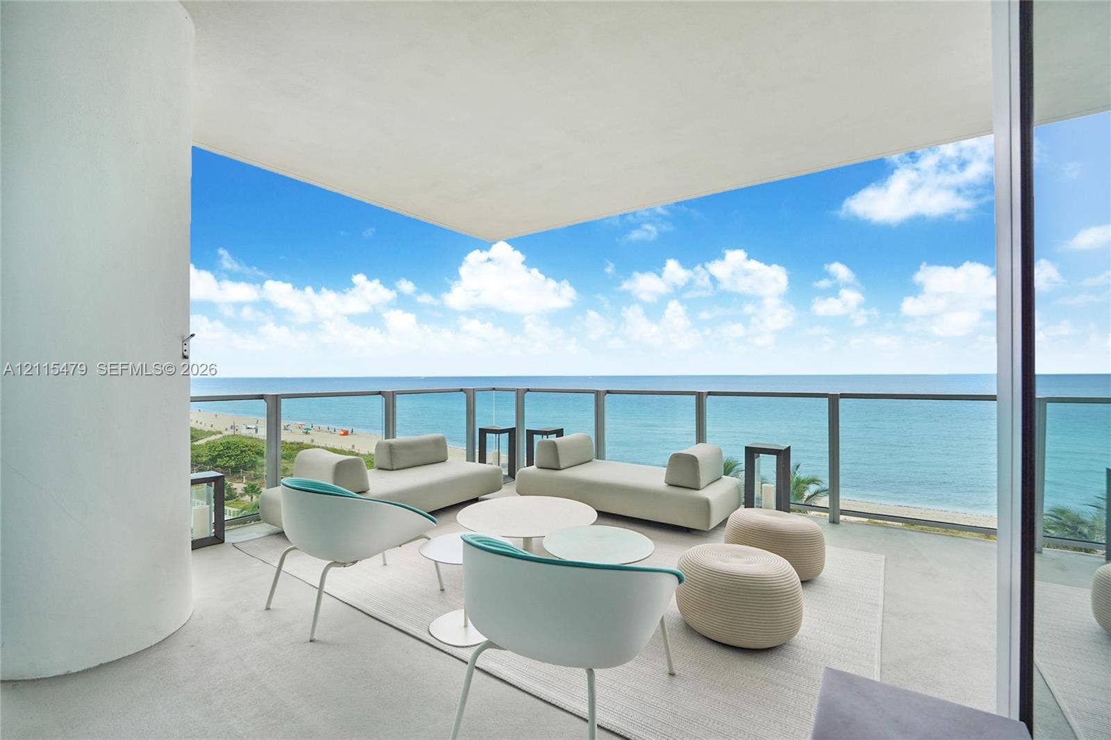 Covered terrace featuring glass panel railings, concrete flooring, and an unobstructed ocean horizon