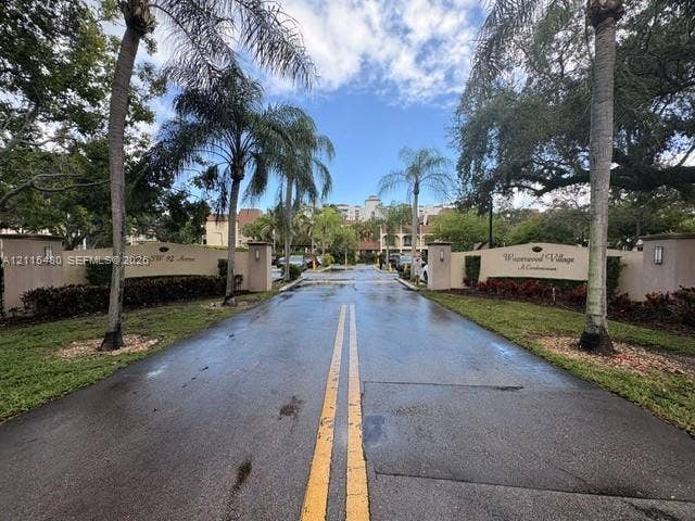 9301 SW 92nd Avenue, #A418, Miami, Miami, FL 33176 Gated community entrance featuring dual stucco monument signage, palm tree landscaping, and paved driveway