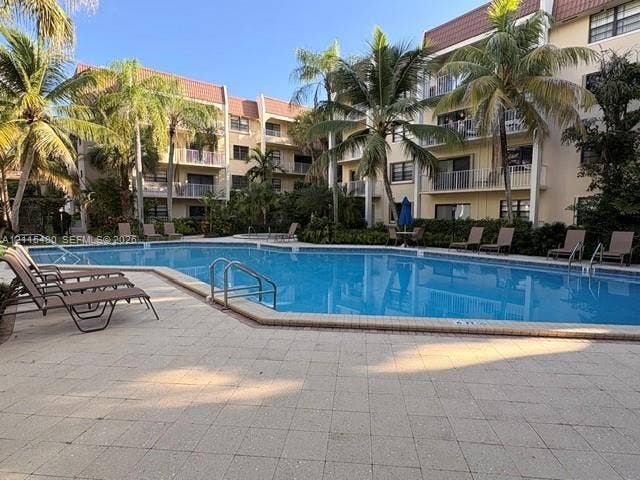9301 SW 92nd Avenue, #A418, Miami, Miami, FL 33176 Community swimming pool featuring a paved deck, metal railings, and perimeter palm trees