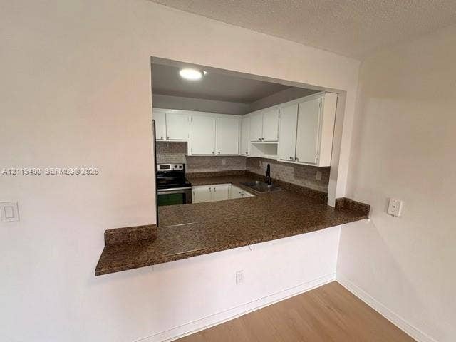 9301 SW 92nd Avenue, #A418, Miami, Miami, FL 33176 Kitchen pass-through featuring an expansive stone-finish countertop, white cabinetry, integrated stainless steel appliances, and a double-basin sink