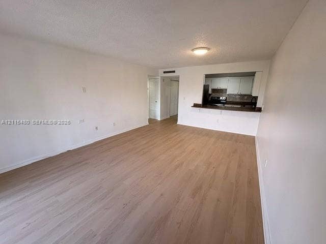 9301 SW 92nd Avenue, #A418, Miami, Miami, FL 33176 Open-concept area featuring wood-finish flooring, a pass-through opening, and a built-in breakfast bar