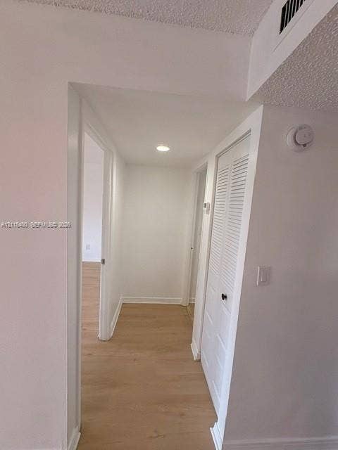 9301 SW 92nd Avenue, #A418, Miami, Miami, FL 33176 Hallway featuring wood-finish flooring, recessed lighting, and white louvered closet doors