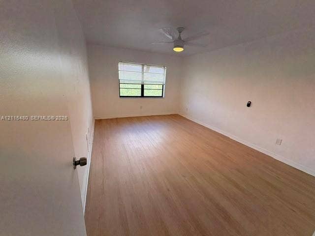 9301 SW 92nd Avenue, #A418, Miami, Miami, FL 33176 Room featuring wood-finish flooring, a multi-pane window with white blinds, and a ceiling-mounted fan with integrated lighting