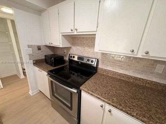 9301 SW 92nd Avenue, #A418, Miami, Miami, FL 33176 Kitchen featuring white cabinetry, stone-finish countertops, subway-style tiled backsplash, stainless steel electric range, and pantry storage